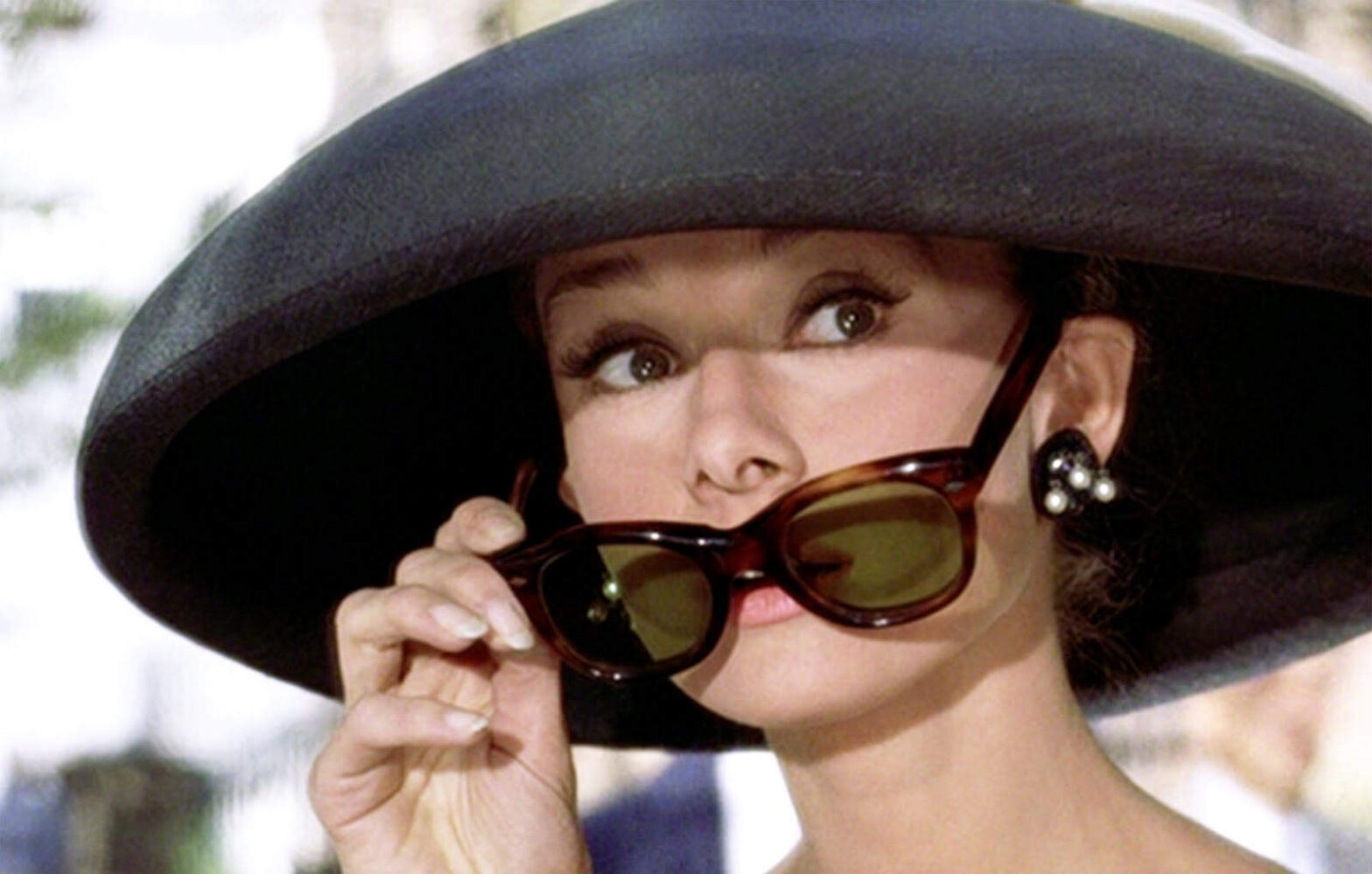 Iconic shot of Audrey Hepburn pulling down her sunglasses